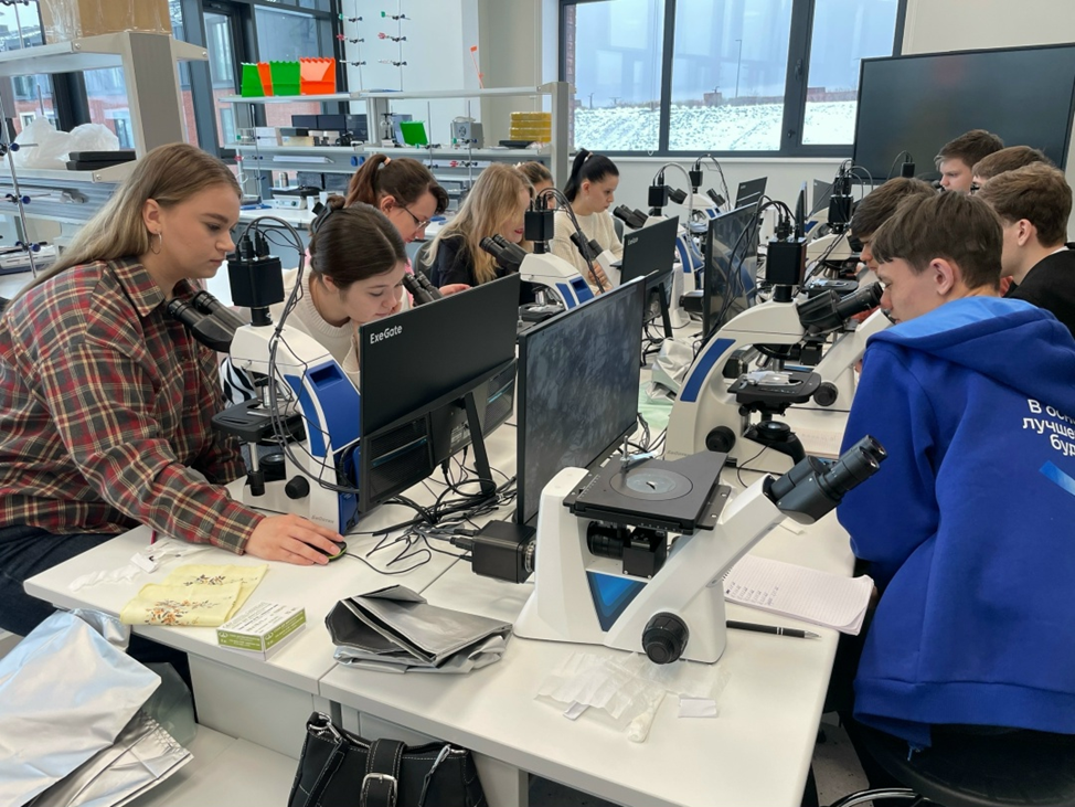 Студенты работают с микроскопами в лаборатории